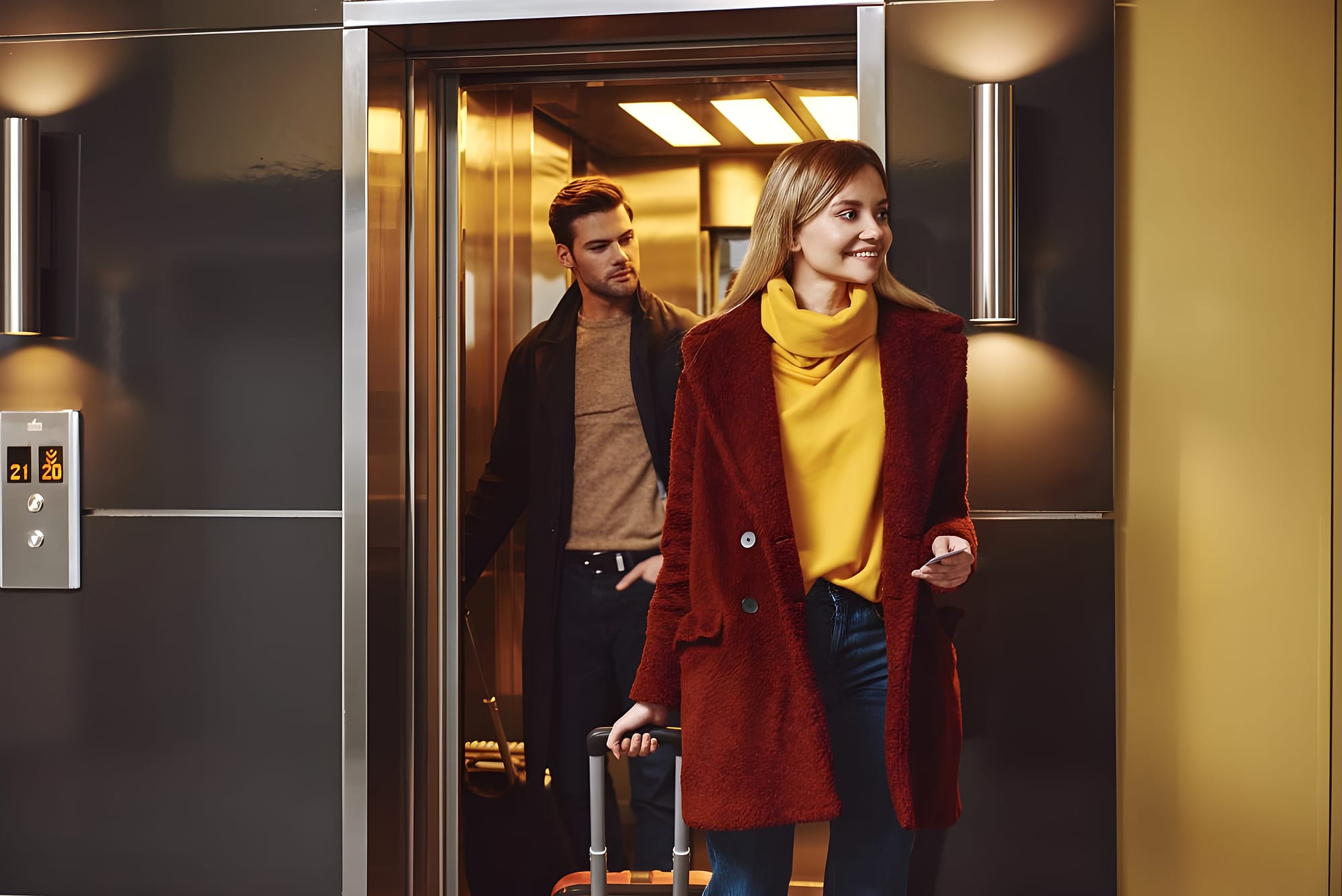 Couple with luggage stepping out of a hotel elevator