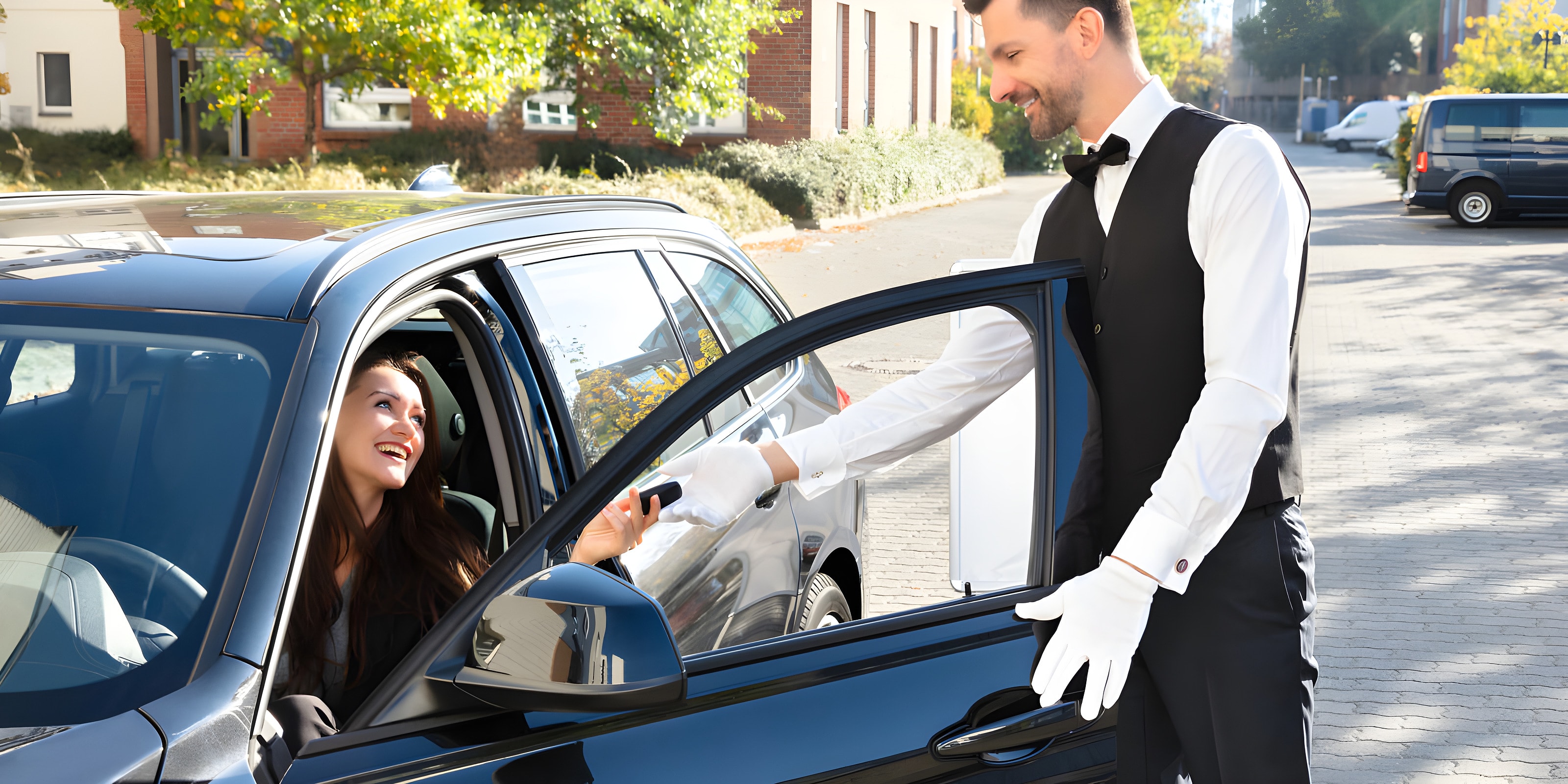 Valet opening a car door for an arriving guest